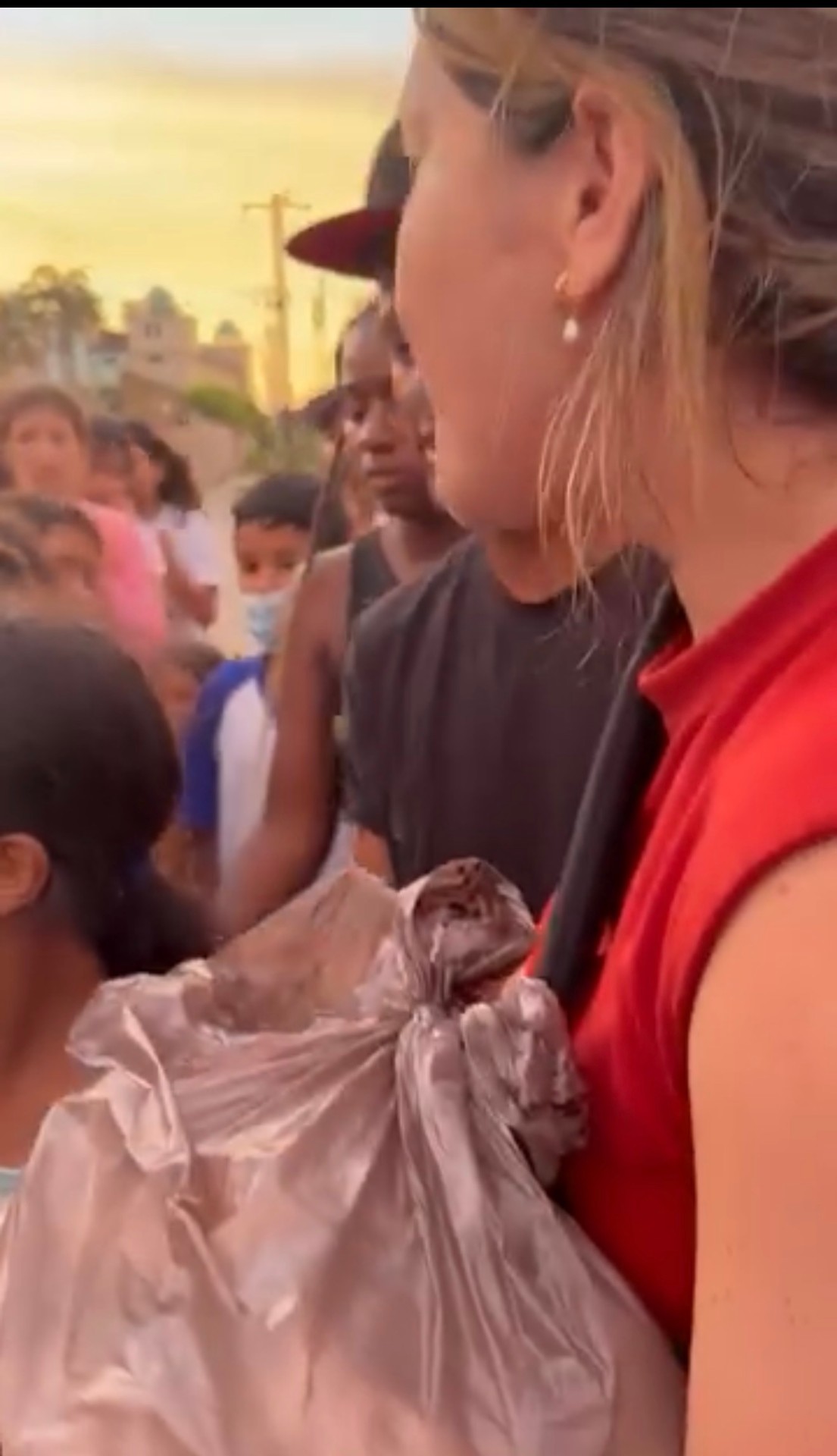Entrega de ayuda a niños y familias en la calle al atardecer